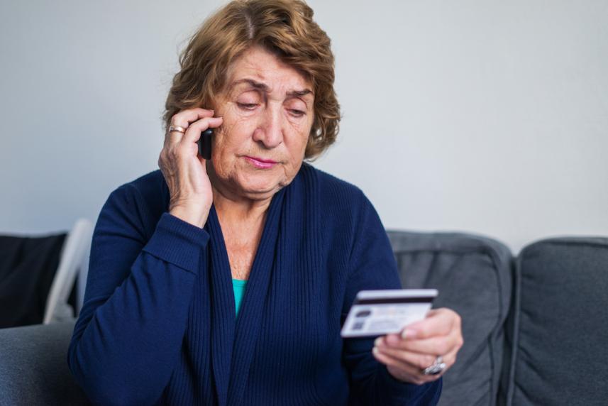 older woman looking at credit card